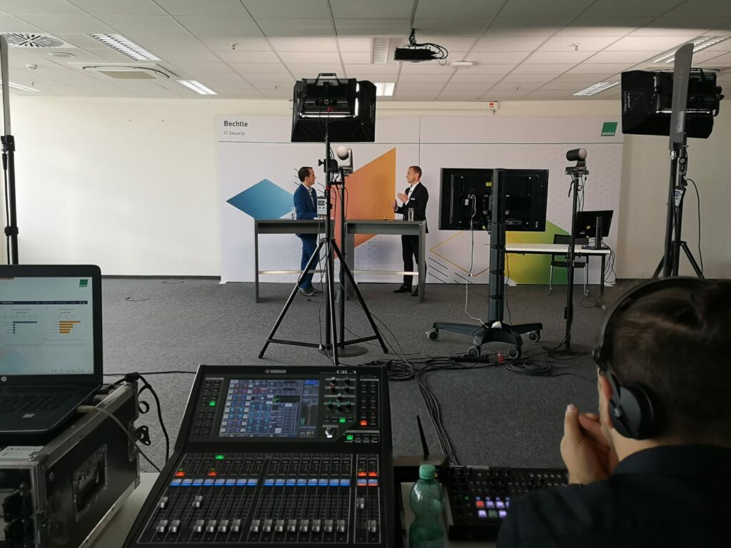 A mixing desk and a laptop, with spotlights in front of it. Ferry van Saalbach can be seen in the background.